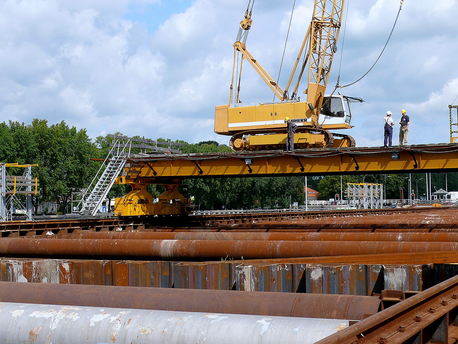 Workers and a crane on a metro construction site